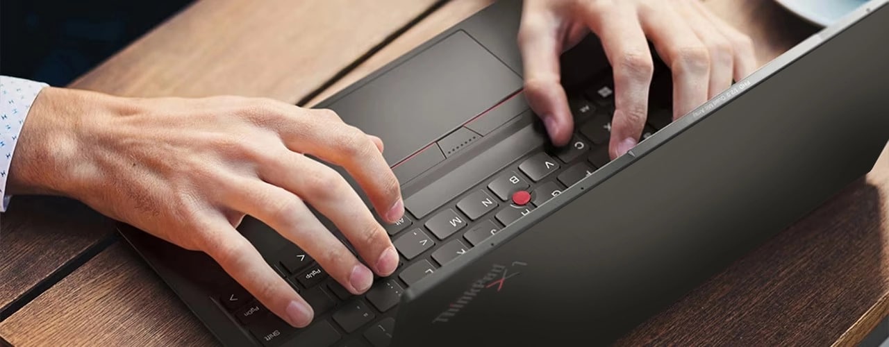 Ảnh chụp từ trên cao của máy tính xách tay Lenovo ThinkPad X1 Nano Gen 3 đang được sử dụng trên bàn, cho thấy mặt trên của Thanh Truyền thông kim trên bàn phím.