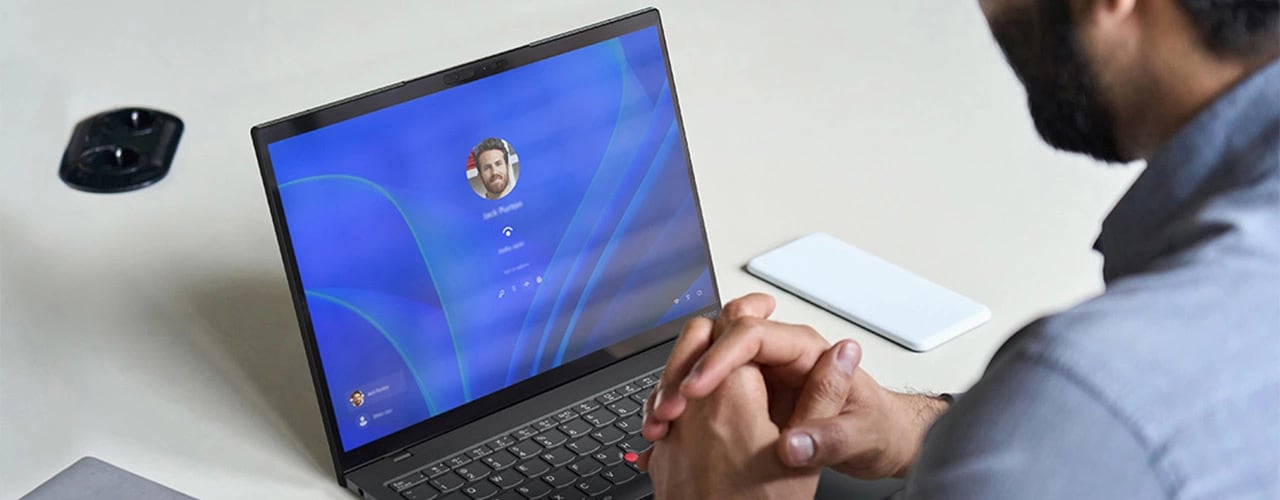 Cuộc gọi video trên máy tính xách tay Lenovo ThinkPad X1 Nano Gen 3 được sử dụng trên bàn làm việc, cùng với điện thoại và máy tính xách tay.